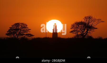 Die Sonne geht hinter dem St Mary's Lighthouse in der Nähe von Whitley Bay, Northumberland, auf. Stockfoto