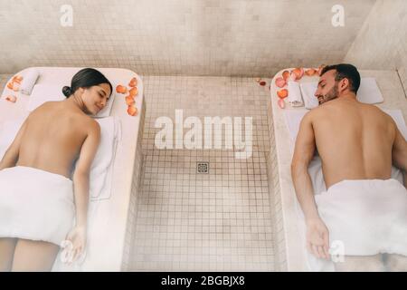 Junge schöne Paar verbrachte Freizeit in einem türkischen Bad. Heißer Dampf wärmte die Körper eines Mannes und einer Frau in einem Hammam Stockfoto