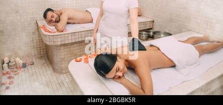 Gemischte Rasse Frau mit Haut Peeling in türkischen Hammam, während ihr Freund genießt die Wärme eines türkischen Bad Marmor Massageliege Stockfoto