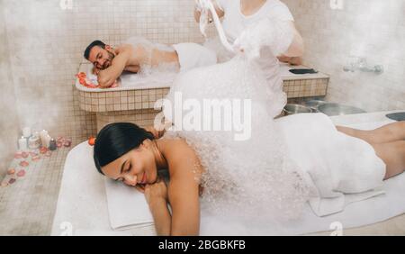 Hammam-Gäste genießen eine Schaummassage im türkischen Bad. Verfahren im orientalischen Bad verbessert die Haut und stoppt Alterungsprozess Stockfoto