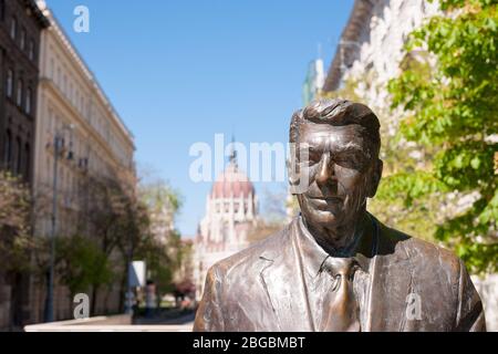 BUDAPEST, UNGARN - 20. APRIL 2020: Statue des ehemaligen US-Präsidenten Ronald Reagan auf dem Hintergrund des ungarischen Parlamentsgebäudes Stockfoto