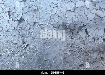 Die Textur der alten gemalten Wand ist mit Rissen und Rauheit Nahaufnahme bedeckt. Stock Foto von alter Farbe mit Rissen. Farbe Silber, Chrom Farbe. Stockfoto