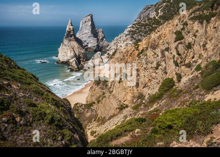 Bizarre Felsen am Strand Praia Da Ursa, Sintra, Portugal. Hohe Klippen und Wellen des Atlantischen Ozeans in der Nähe des berühmten Cabo Da Roca in Portugal. Stockfoto