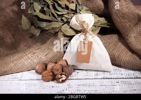 Sack voll mit Gewürzen, auf Holztisch, auf Sack-Hintergrund Stockfoto