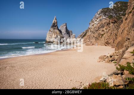 Hohe Felsklippen am Strand Praia Da Ursa, Sintra, Portugal. Atlantische Wellen und Sandstrand in der Nähe des berühmten Cabo Da Roca in Portugal. Stockfoto