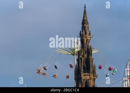 Fair Ground Ride und Scott Monument, Princes Street Gardens während der Weihnachtszeit in Edinburgh, Schottland. Stockfoto