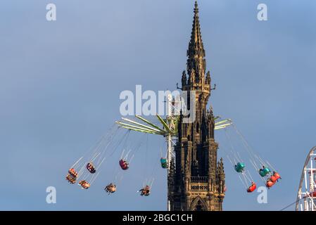 Fair Ground Ride und Scott Monument, Princes Street Gardens während der Weihnachtszeit in Edinburgh, Schottland. Stockfoto