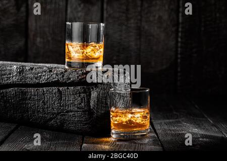 Zwei Gläser Eis Whiskey auf verbrannten Brettern Stockfoto