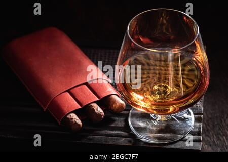 Gereiftem Cognac und Zigarre auf altem Humidor Stockfoto