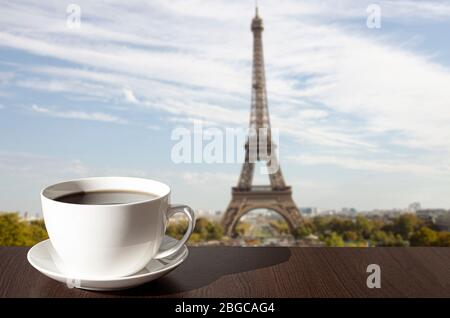Tasse Kaffee auf dem Tisch mit Blick auf den Eiffelturm in Paris, Frankreich Stockfoto