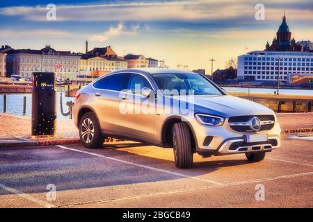 Das silberne Mercedes-Benz EQ Power Hybridauto wird an der Helen Vehicle Charging Point an der Strandpromenade in Helsinki, Finnland, aufgeladen. 18. April 2020. Stockfoto