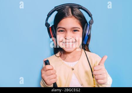 Nette kleine gemischte Rasse Kind während Verfahren Hörprüfung. Mädchen tragen spezielle Kopfhörer bekommen Hörtest, Audiometrie Stockfoto