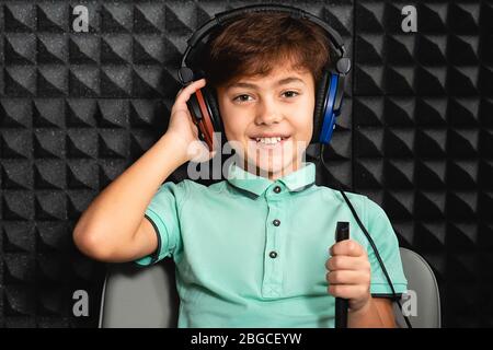Positive kleine gemischte Rasse Junge trägt Kopfhörer mit exam.audiometry Test hören Stockfoto