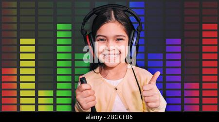 Positive gemischte Rasse Mädchen trägt Kopfhörer bekommen Hörtest, Audiometrie, Sound-Equalizer auf dem Hintergrund. Untersuchung des Gehörs von Kindern Stockfoto