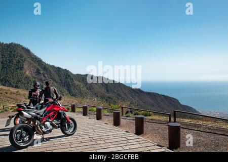 Zwei junge Motorradfahrer hielten am Aussichtspunkt Mirador de Chivisaya an, um sich auszuruhen und den Panoramablick zu genießen Stockfoto