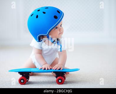 Nettes Baby Baby Mädchen in Schutzhelm Outfit bereit, Skateboard, Extremsport-Konzept zu fahren Stockfoto