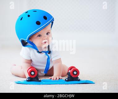 Nettes Baby Baby Mädchen in Schutzhelm Outfit bereit, Skateboard, Extremsport-Konzept zu fahren Stockfoto