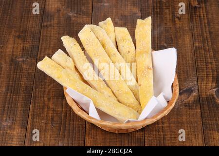 Brotstangen in Korbkorb auf Holzhintergrund Stockfoto