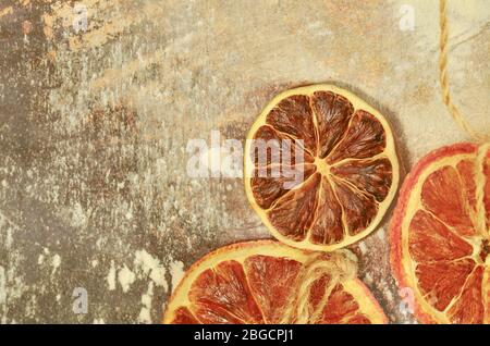 Getrocknete Früchte Mandarinen, Orangen und Limonen. Getrockneter Kalk, Orangen auf einem Metallofen. Natürliche Einrichtung auf Metallhintergrund. Stockfoto