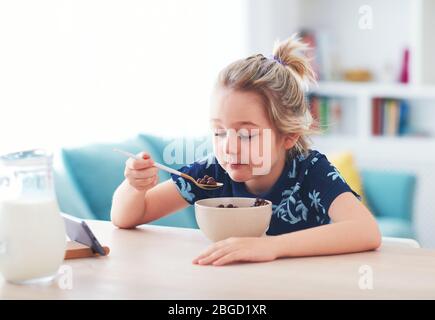 Netter kleiner Junge ist am Morgen frühstücken Stockfoto