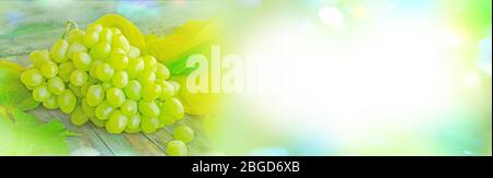 Trauben mit Blättern auf dem Holzhintergrund. Trauben auf Holztisch. Ansicht mit Kopierbereich Stockfoto