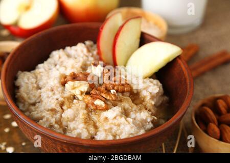 Leckere Haferflocken mit Nüssen und Äpfeln auf dem Tisch aus nächster Nähe Stockfoto