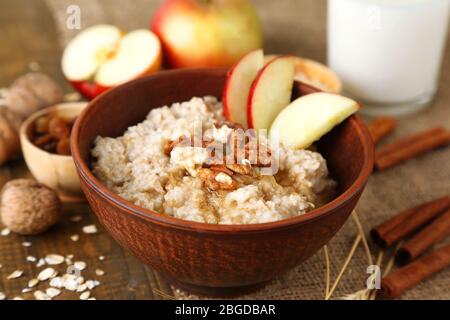 Leckere Haferflocken mit Nüssen und Äpfeln auf Holztisch Stockfoto