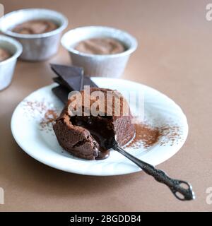 Konzept der Nachspeise. Geschmolzene Schokolade Lava Kuchen auf braunem Hintergrund. Draufsicht. Selektiver Fokus. Stockfoto