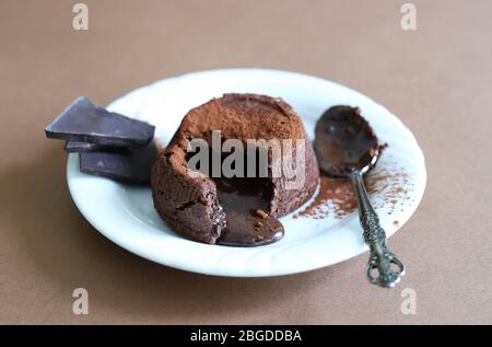 Konzept der Nachspeise. Geschmolzene Schokolade Lava Kuchen auf braunem Hintergrund. Draufsicht. Selektiver Fokus. Stockfoto