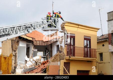 Feuerwehrleute an einem Straßenkran, die an einem eingestürzten Gebäude arbeiten. Stockfoto