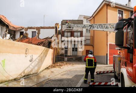 Feuerwehrleute montiert auf einem Feuerwehrwagen Kran auf der Straße arbeiten an einem eingestürzten Bau Stockfoto