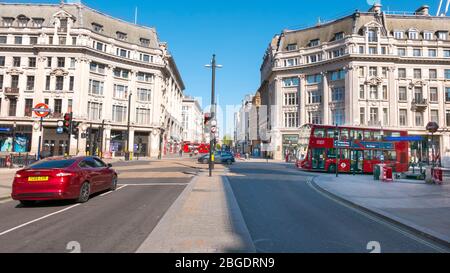 Coronavirus Pandemie ein Blick auf den Oxford Circus in London April 2020. Keine Leute, nur ein paar Busse in den Straßen, alle Geschäfte geschlossen für Lockdown. Stockfoto