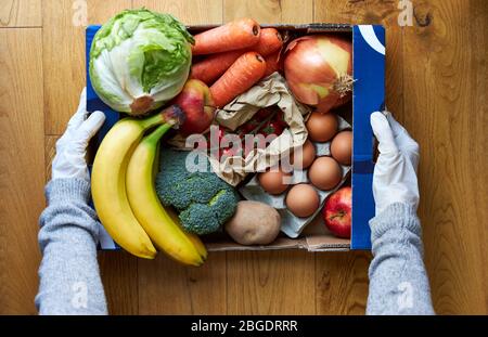 Weibliche tragen Handschuhe mit Marktbox Lieferung Stockfoto