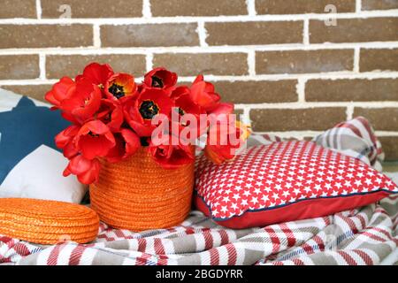 Bunte Tulpen mit Karos und Kissen auf hellem Hintergrund Stockfoto