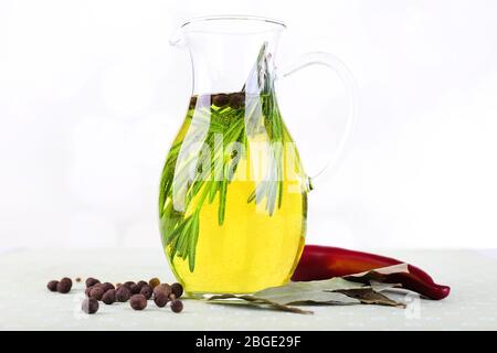 Ätherisches Öl mit Rosmarin in Glaskrug, isoliert auf weiß Stockfoto