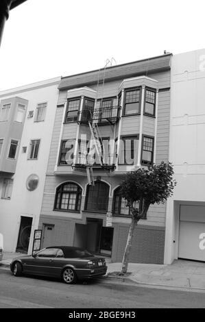 Wohnblock in San Francisco, Kalifornien, USA, Baum, Auto im alten Stil, Soft-Top Garagentorbogen, Bogenförmiges Schild, Straßenbucht Fenster, Glas, Kreisbogen Stockfoto