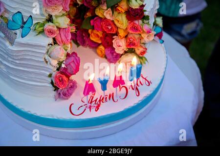 Zwei-Schicht-Kuchen . Hochzeitstorte mit bunten Rosen. Feier Party Konzept. Blumen in der Mitte des Ortes, wo der Kuchen geschnitten wird Stockfoto