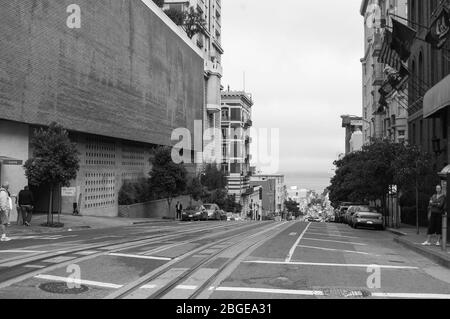 San Francisco Hill Street Seilbahnen verfolgen Flaggen USA USA California People Walking Hills beherbergt Büros in Schwarz-Weiß-Stil Stockfoto