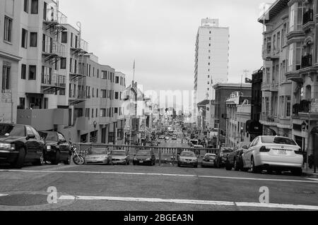 Blick auf San Francisco Autos Alcatraz Hügel Schienen geparktes Wassergebäude Gebäude Flaggen Motorradleuchten Licht neblig tagsüber Balkon Stockfoto