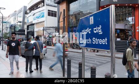 Blick auf die berühmte Kirche Straße Schild an der MG Straße mit den Menschen, die die Straße in Bewegung verschwimmen Stockfoto