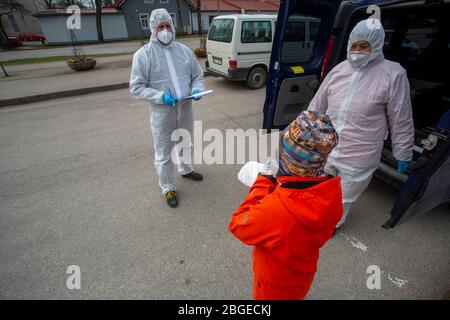 (200421) -- OGRE, 21. April 2020 (Xinhua) -- Mitarbeiter verteilen kostenlose Nahrung an ein Kind aus einem Haushalt mit niedrigem Einkommen in Ogre, Lettland, 20. April 2020. Lettland hat den Ausnahmezustand bis Mai 12 verlängert. (Foto von Janis/Xinhua) Stockfoto