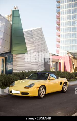 Ein gelber Sportwagen in der Stadt, Gebäude um Stockfoto