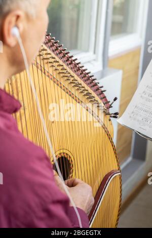 Musiker, der die Bandura spielt, zu Hause Proben. Pandora ist ein traditionelles ukrainisches Musikinstrument Stockfoto