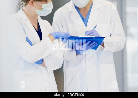 Diskussion zweier Ärzte in Schutzhandschuhen Stockfoto