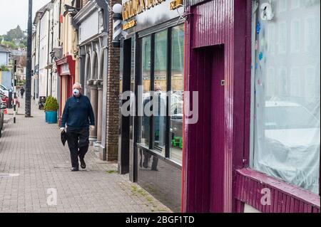 Bandon, West Cork, Irland. April 2020. Ein Mann geht Bandon Main Street hinunter und trägt eine Gesichtsmaske, um sich vor Covid-19 zu schützen. Credit: AG News/Alamy Live News Stockfoto