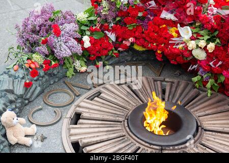 Blumen-Kinderspielzeug für das Denkmal Ewiger Brand für den unbekannten Soldaten. Kiew, Ukraine Stockfoto