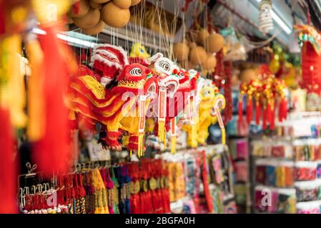 Chinesische Löwendekorationen hängen auf dem Straßenmarkt in Chinatown. Das Chinesische Neujahr (Frühlingsfest) Feiern. Chinesischer Text: Glück und Glück Stockfoto