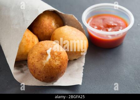 Gebratenes Risotto Arancini gefüllt mit Käse, serviert mit Tomatensauce Stockfoto