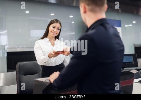 gut aussehend Geschäftsmann Übergabe Flugticket bei Airline Check-in Schalter Stockfoto