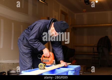 Handwerker schneiden Holz mit Stichsäge auf der Baustelle. Stockfoto